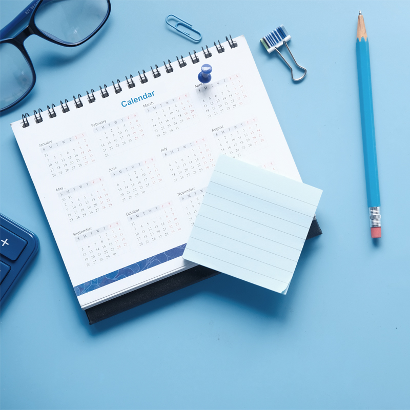 Fristen im Blick Ein Kalender mit Notizen und Schreibmaterial – wichtige Termine wie Karenzfristen oder Einreichefristen für Rückerstattungen sollte man im Auge behalten.