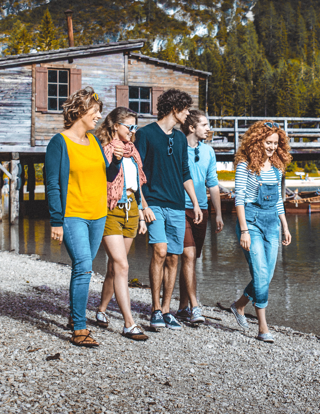 Gemeinsam unterwegs Fünf junge Menschen spazieren am Seeufer entlang – ein Moment der Leichtigkeit, der zeigt, was Freizeit mit MiBon bedeuten kann: Gemeinschaft, Natur und Freude.