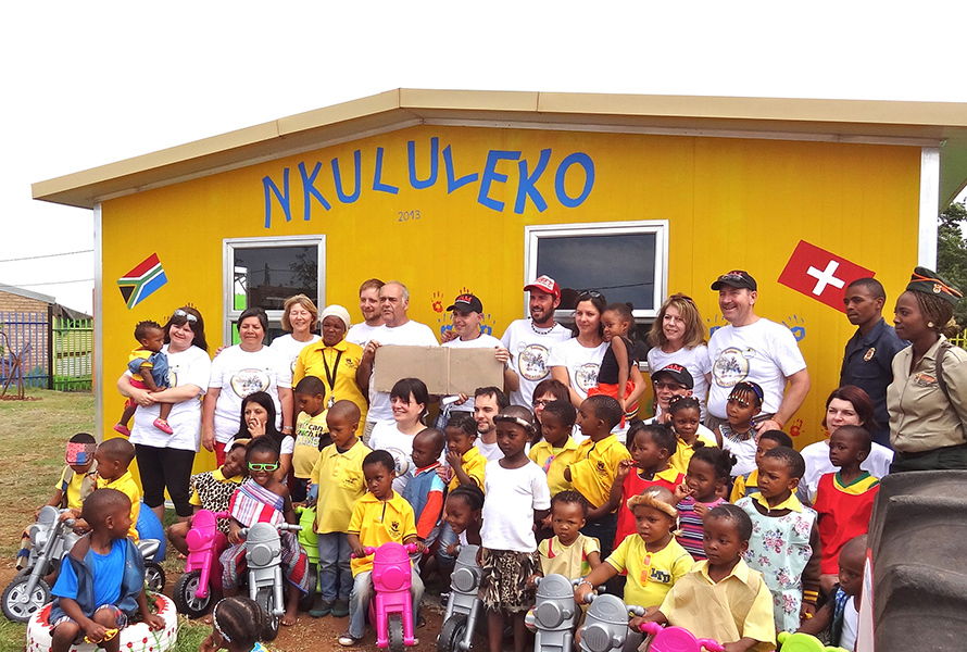 Ein starkes Team für starke Kinder Das Bauteam steht gemeinsam mit den Kindern von Nkululeko stolz vor dem neu errichteten Gebäude – ein Moment voller Hoffnung und Zusammenhalt.