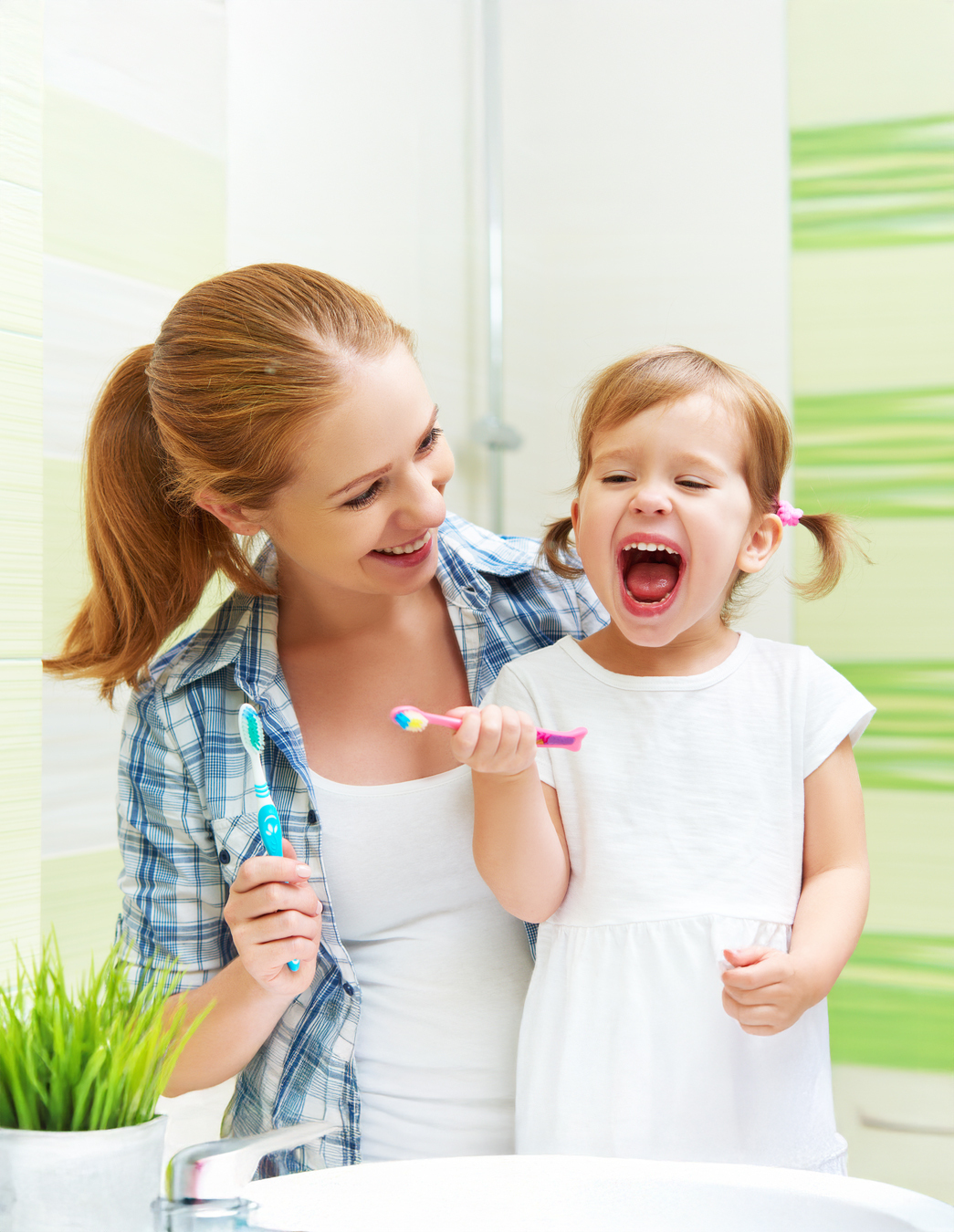 Zähneputzen mit Mama Ein kleines Mädchen steht mit seiner Mutter am Lavabo – tägliche Zahnpflege beginnt zu Hause, die finanzielle Unterstützung kommt von PRO LIFE.