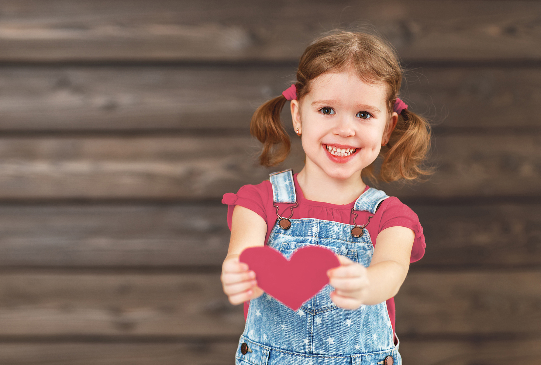 Mädchen hält Herz Ein Mädchen streckt ein Herz in Richtung Kamera – ein starkes Symbol für Liebe, Fürsorge und Menschlichkeit.