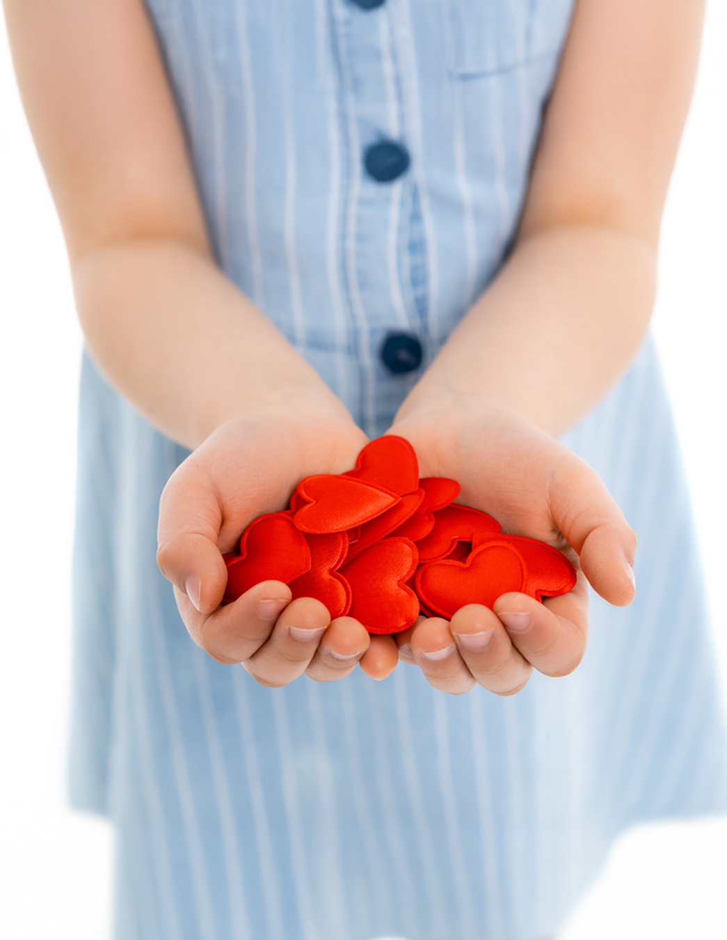 Geben verbindet Ein kleines Mädchen hält die Hände offen – darauf eine Fülle roter Herzen. Ein emotionales Bild für Fürsorge, Vertrauen und gegenseitige Unterstützung.