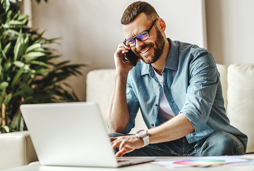 Direkter Draht zu uns Ein Mann arbeitet konzentriert am Laptop und telefoniert – unkomplizierter Kontakt für Ihre Anliegen.