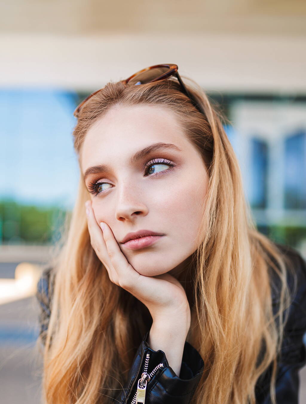 Nachdenkliche Schwangere Eine junge Frau stützt nachdenklich den Kopf auf die Hand – die Frage, wann sie die Schwangerschaft verkündet, beschäftigt sie.