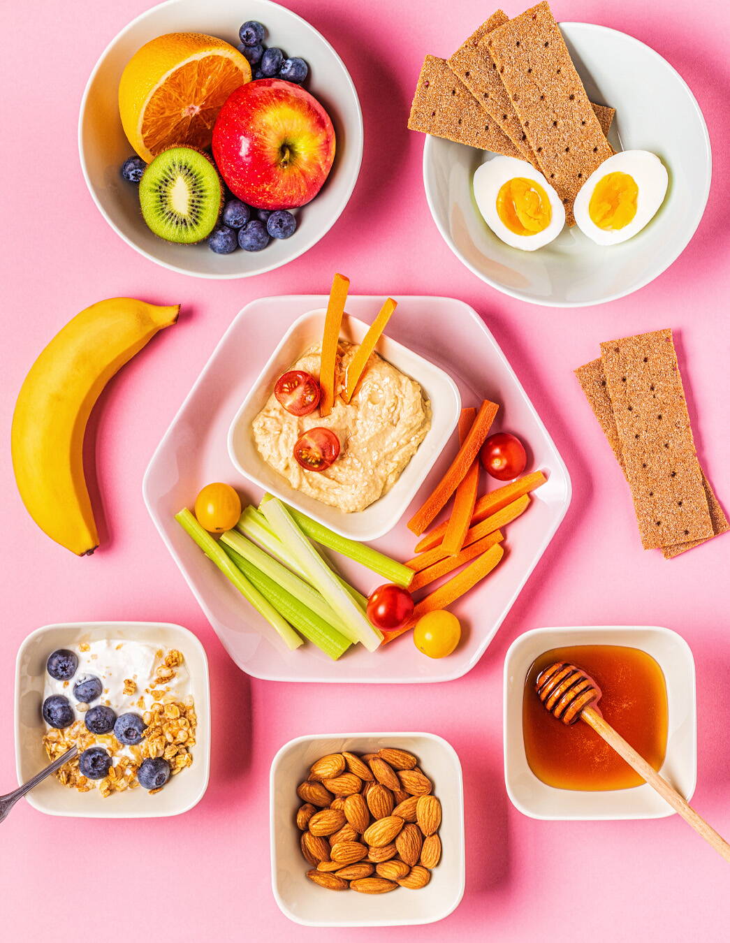 Snack sani contro la fame improvvisa Un mix sano di hummus con verdure, frutta fresca, noci, miele, pane croccante integrale e un uovo – l’ideale per affrontare gli attacchi di fame in gravidanza