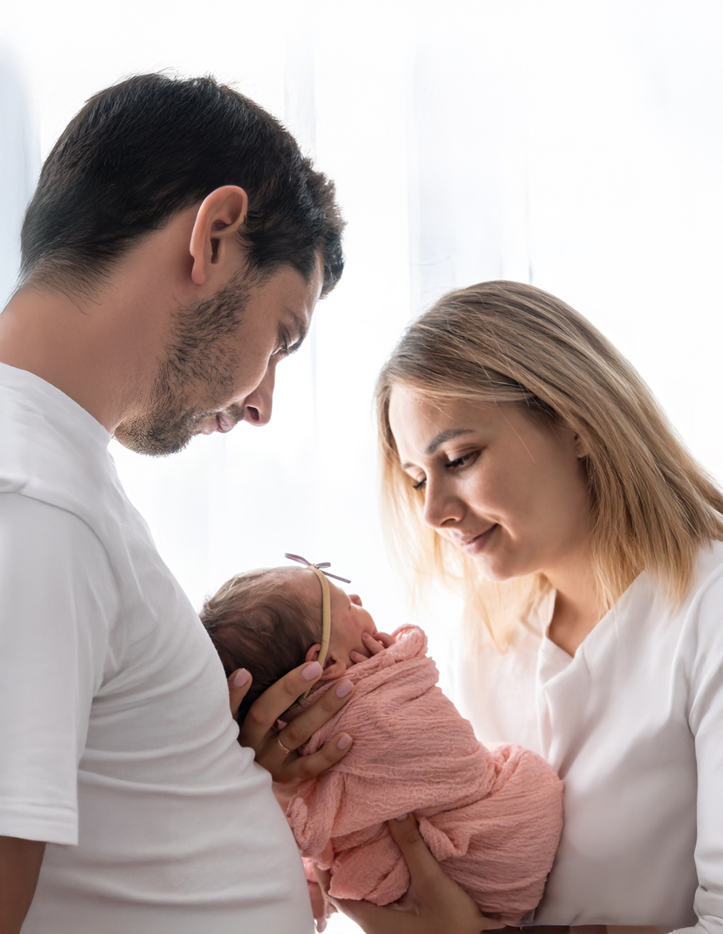 Endlich angekommen Ein glückliches Paar schaut liebevoll auf das Neugeborene in den Armen der Mutter – ein emotionaler Moment nach einer langen Reise voller Vorfreude und Geduld.