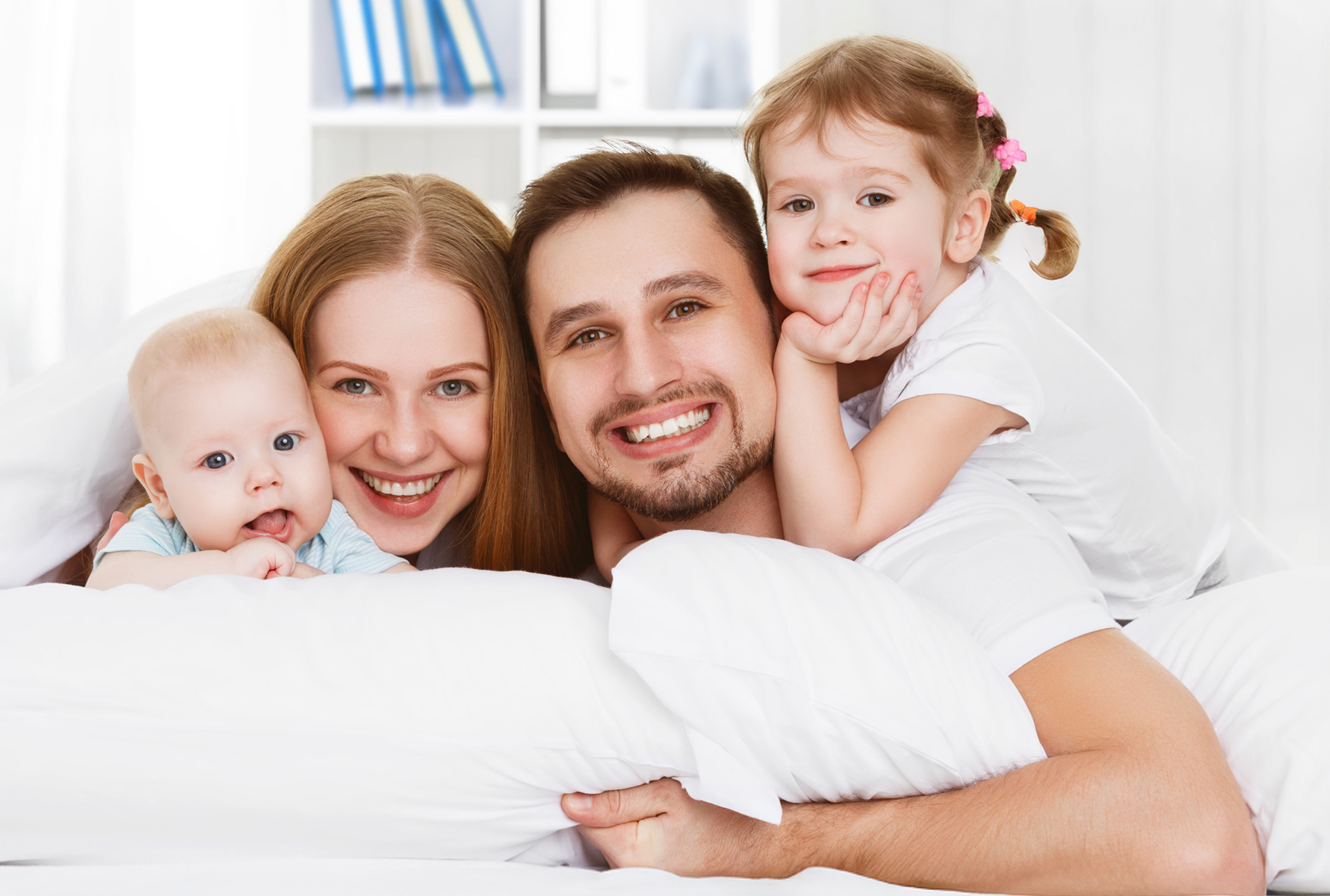 Glückliche Familie gemeinsam Eine Familie aus Vater, Mutter und zwei Kindern schaut lächelnd in die Kamera – symbolisch für Zusammenhalt und Lebensfreude.